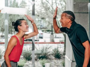 a joyful exchange between colleagues sharing a high five inside a modern office