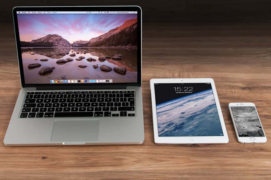 modern workspace showcasing apple laptop tablet and smartphone on a wooden desk